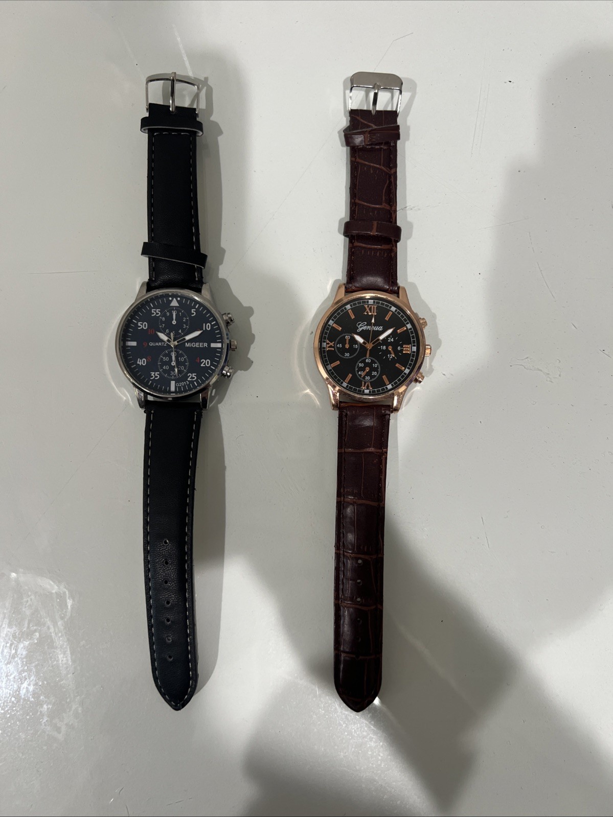 Two Men’s wristwatches. Blue Migeer W Black Band. Black And Rose Gold Geneva